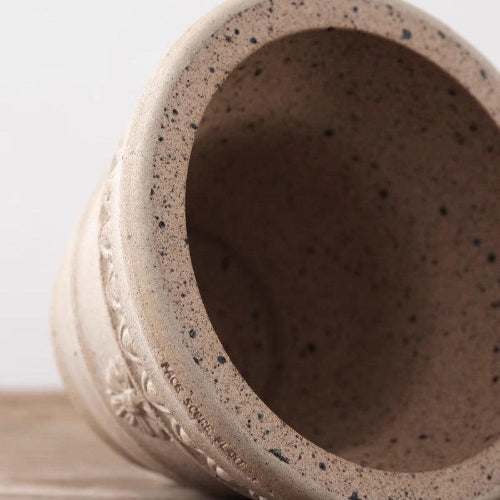 7-inch sculpted clay planter with drainage hole, light brown color, textured floral design, perfect for small plants.