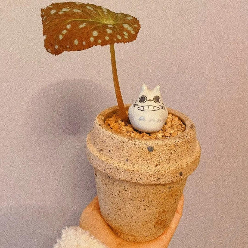 4-inch tiny stoneware planter in a coffee cup shape, featuring a small succulent with decorative figurine, speckled beige finish; ideal for indoor decor.