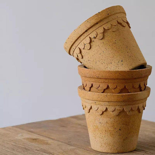 Stack of 6-inch caramel-colored decorative clay pots with scalloped edges. Perfect for displaying plants and enhancing indoor decor.
