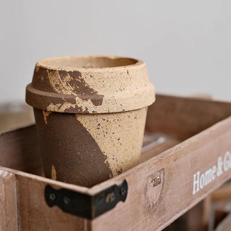 4-inch rustic terracotta pot in a coffee cup shape with earthy brown and beige tones, perfect for small succulents, placed in a wooden tray.