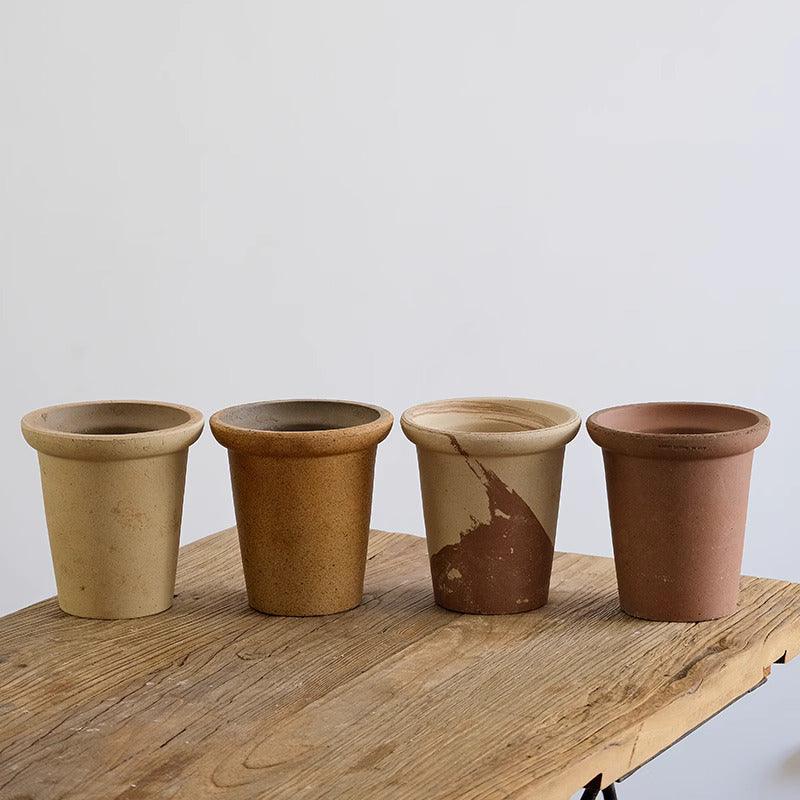 Set of 6-inch terracotta planters in neutral earthy tones. Simple, durable clay pots for small plants with a classic tapered shape and drainage holes.