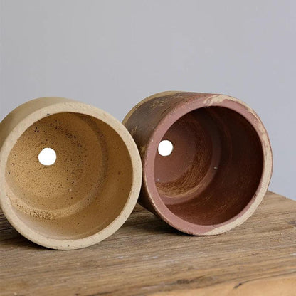 Set of 5-inch clay planters with drainage holes. Simple terracotta pots in natural colors, ideal for small indoor plants.