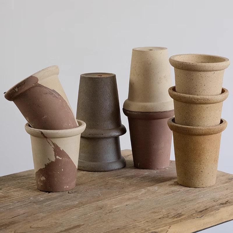 Set of 6-inch terracotta planters in earthy tones, featuring simple cone shapes. Durable clay pots for indoor greenery and small plants.