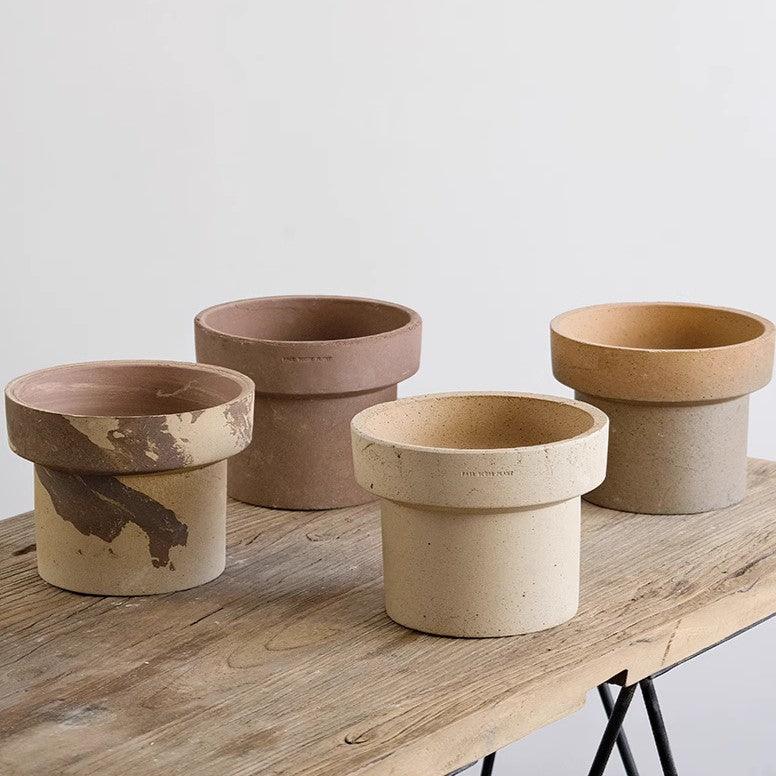 7-inch cone-shaped terracotta pots in earthy beige, brown, and marbled tones, with a rustic ceramic finish on a wooden surface.