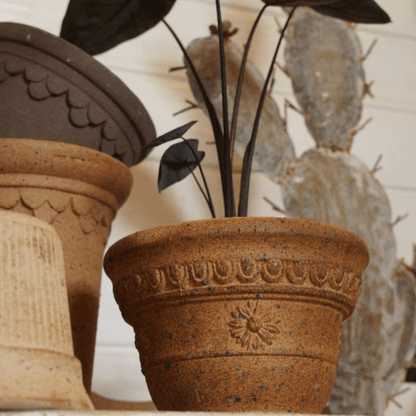 7-inch sculpted clay planter in warm brown tones with floral detail. Sturdy terracotta pot for medium plants, classic shape, and durable design.