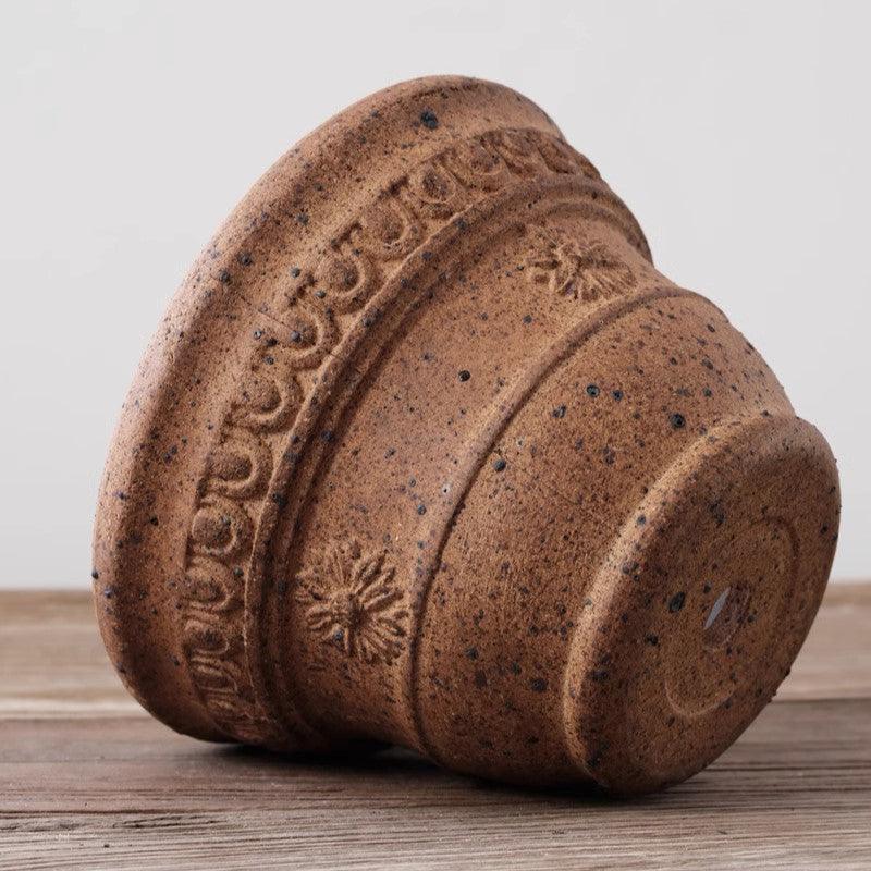 7-inch sculpted terracotta pot with drainage hole, floral details, rustic brown finish, ideal for small plants.