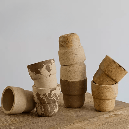 Collection of 4-inch carry cup-shaped clay pots in earthy tones, including marbled, beige, and sand. Ideal for small plants, adding rustic charm to decor.