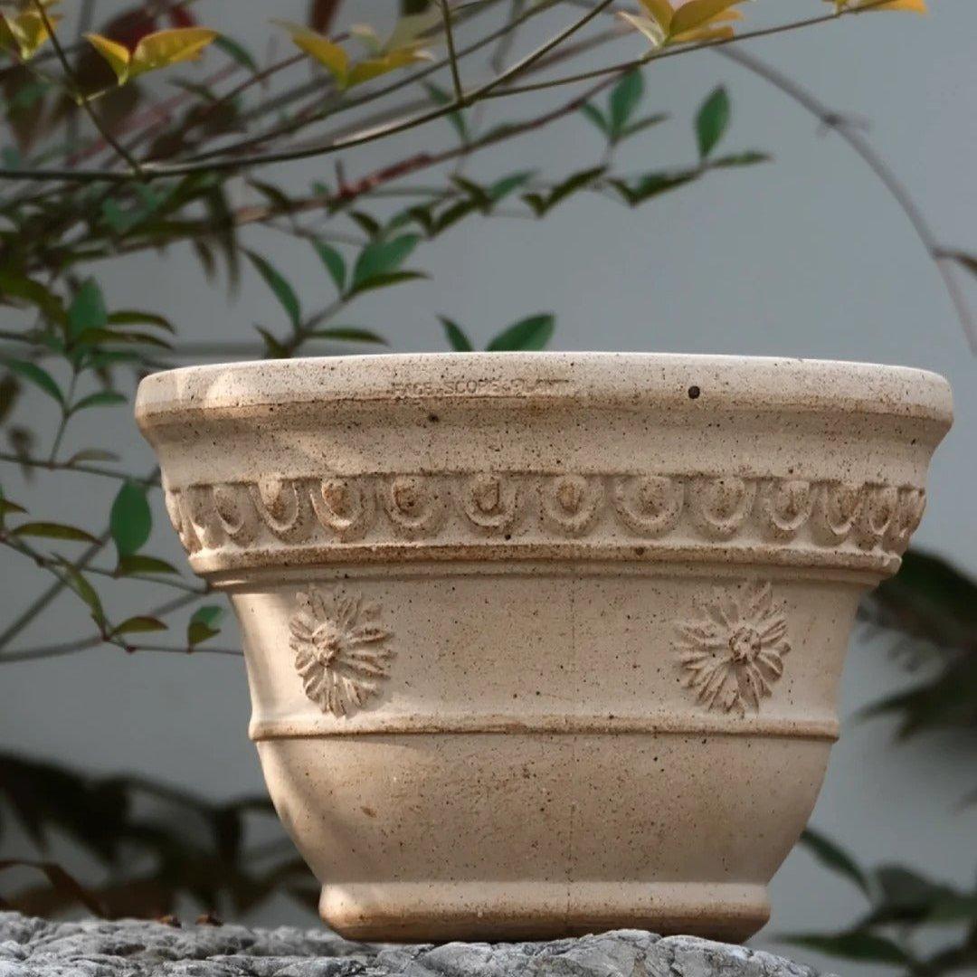 7-inch handmade white sculpted clay planter with floral accents. Ideal for small plants, sturdy ceramic pot.