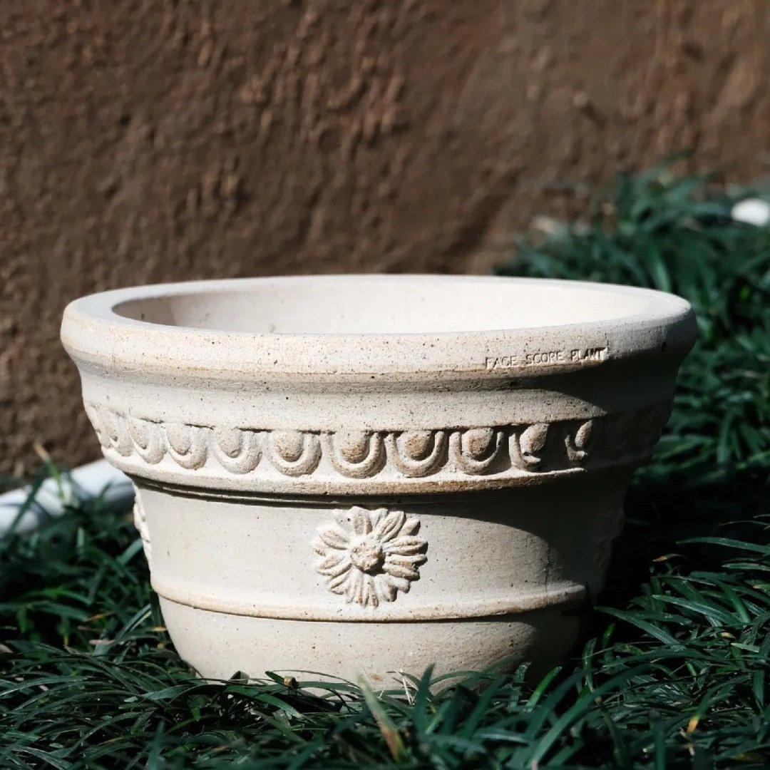 7-inch handmade sculpted white clay planter  with a flower motif, perfect for plants. Sturdy terracotta pot with a classic design.