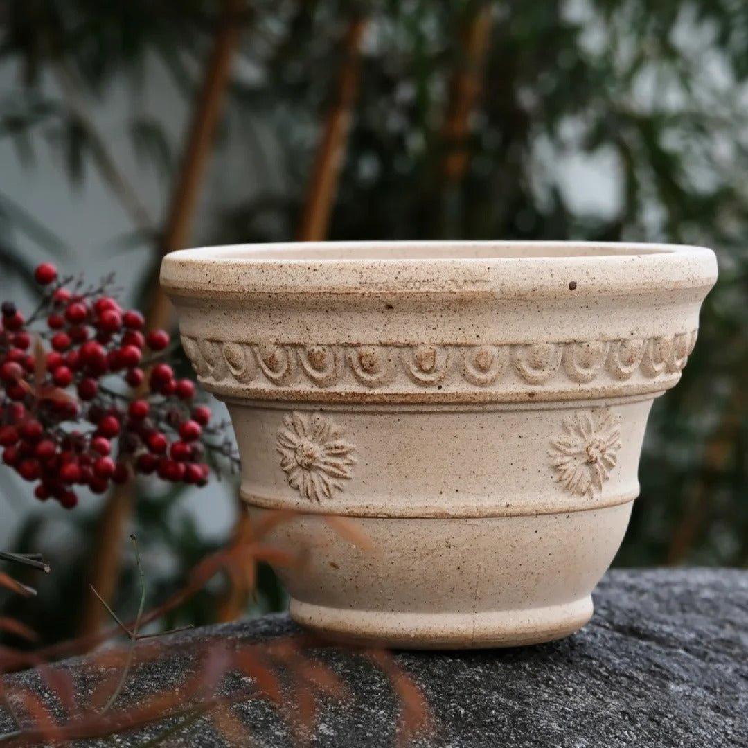 7-inch handmade white sculpted clay pot with floral patterns, perfect for small plants. Sturdy ceramic planter with a classic design.