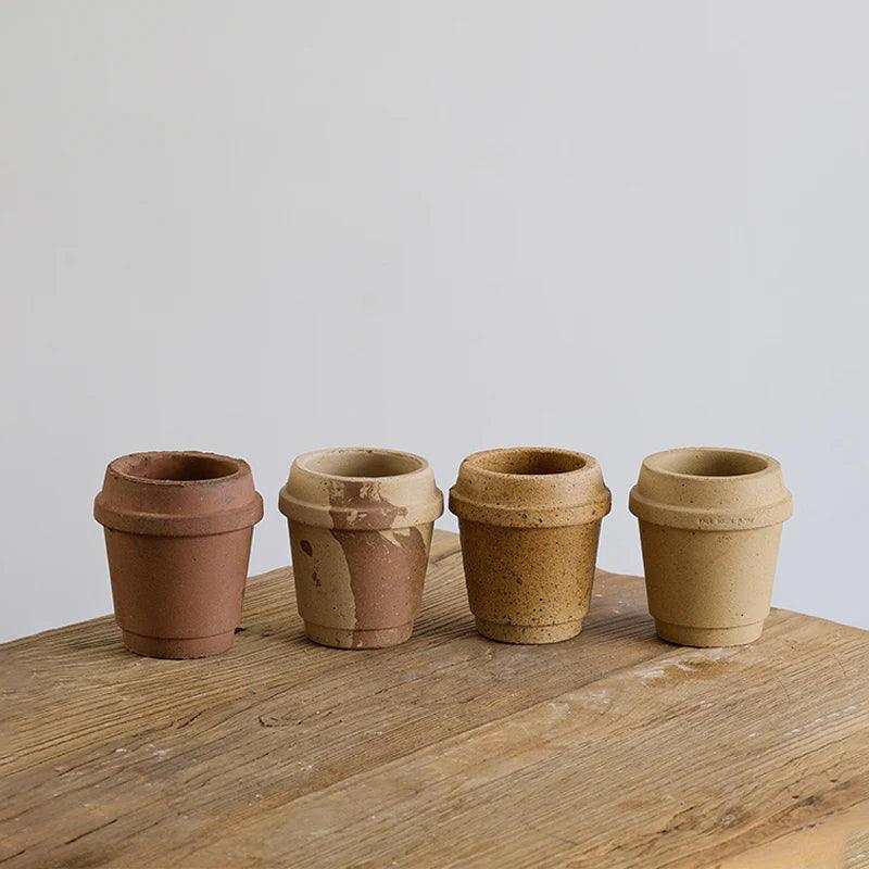 Set of small 4-inch ceramic coffee cup-shaped planters in various earthy tones, ideal for succulents; crafted from terracotta with a rustic finish.