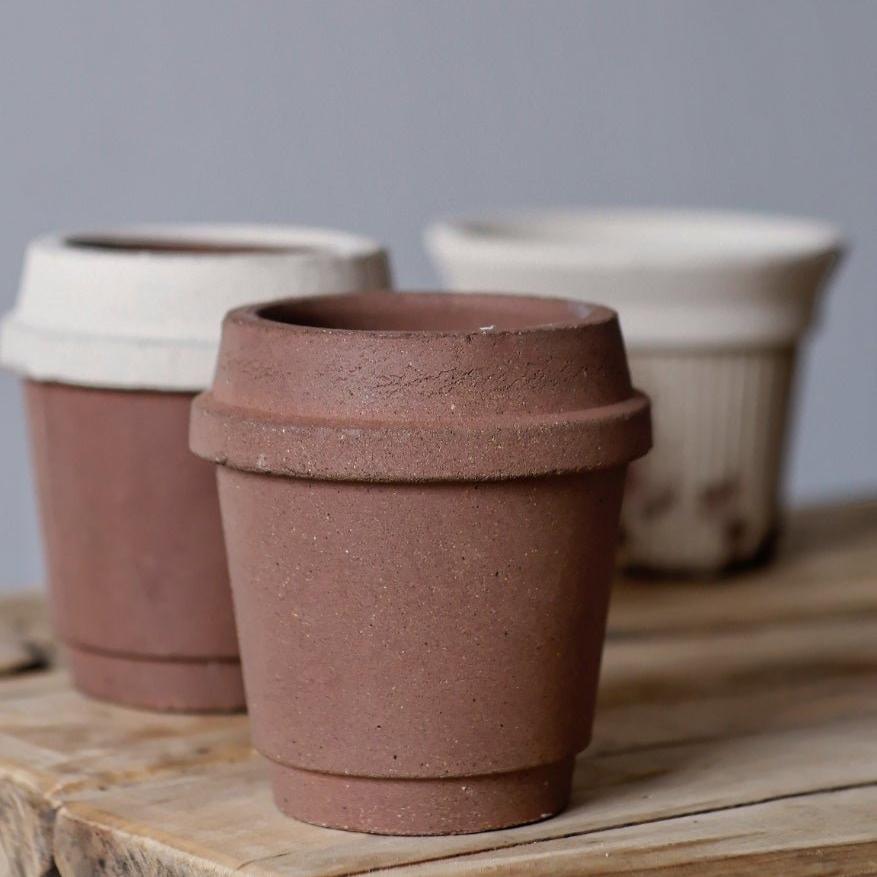 4-inch miniature earthenware pots in coffee cup design, with earthy tones of brown and cream, ideal for small succulents, on a wooden surface.