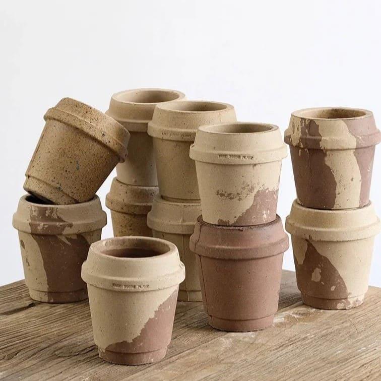 4-inch coffee cup-shaped clay pots in earthy beige and brown tones with a rustic finish, stacked on a wooden surface.