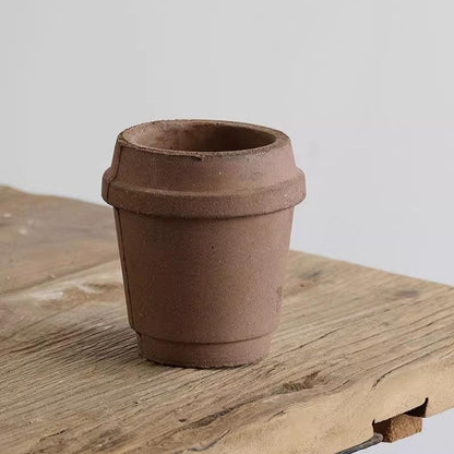 4-inch small clay pot in coffee cup design, earthy brown tone, ideal for tiny succulents; rustic ceramic planter on a wooden surface.