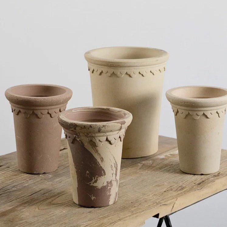 Collection of 7-inch tall clover ceramic pots with decorative edges in earthy tones, ideal for adding elegance to indoor or outdoor decor.