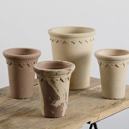 Collection of 7-inch tall clover ceramic pots with decorative edges in earthy tones, ideal for adding elegance to indoor or outdoor decor.