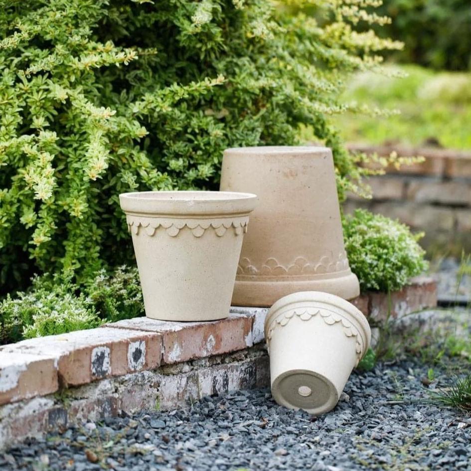 Clover-style white terracotta planter set in various sizes with decorative edges, ideal for outdoor gardens and enhancing landscape decor.